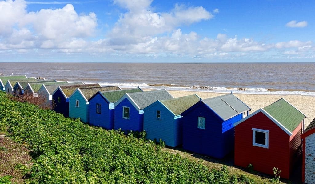 line of beach huts with sea in the background