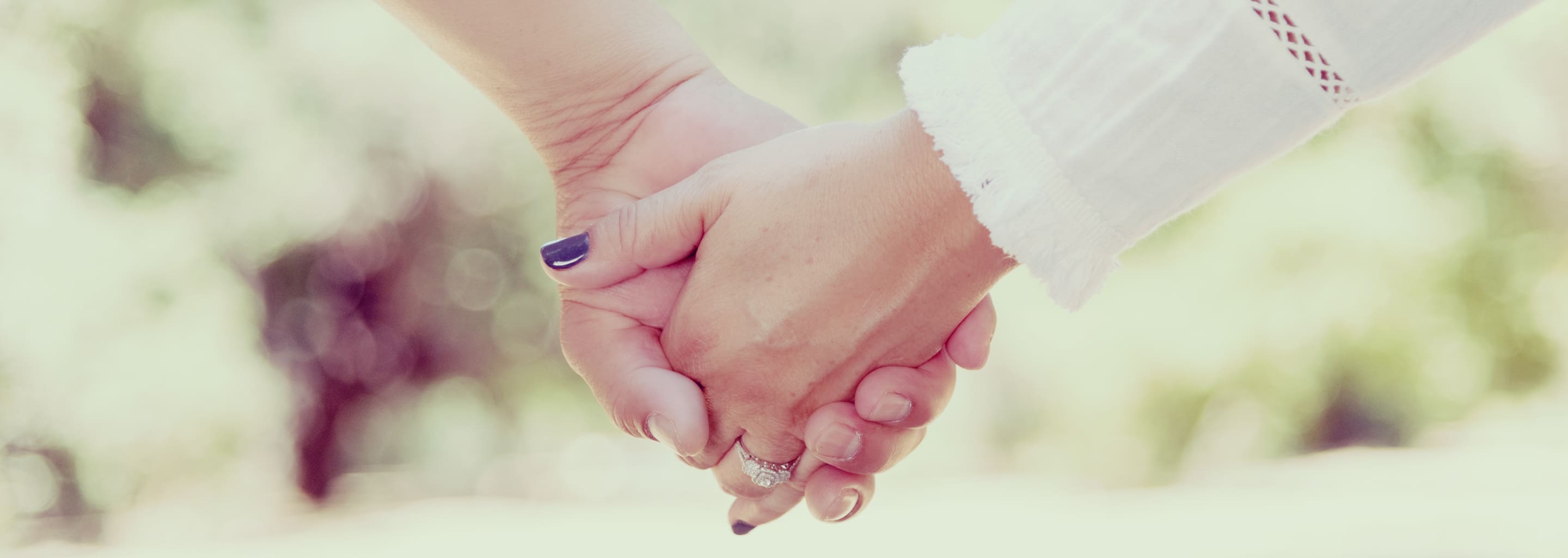 close image of bride and groom holding hands