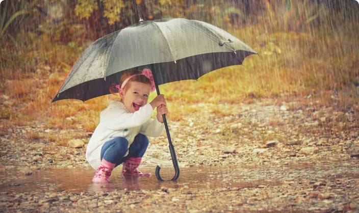 Child under umbrella in the rain