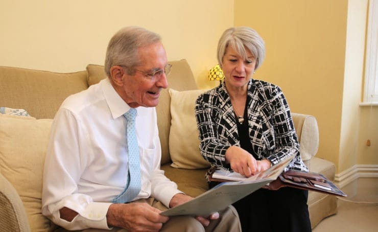 elderly couple looking at booklet together