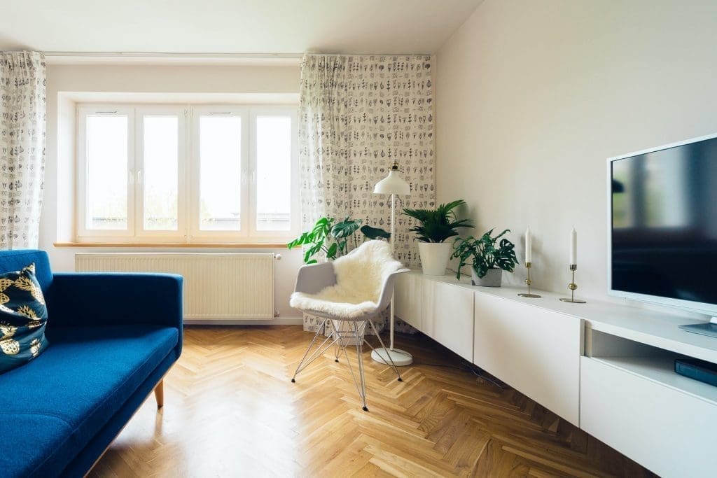 White loft living room, blue sofa and wooden floor