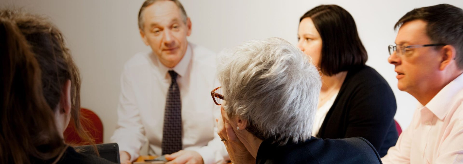 About Hero Image | The Mortgage Centres employees having a meeting round a table