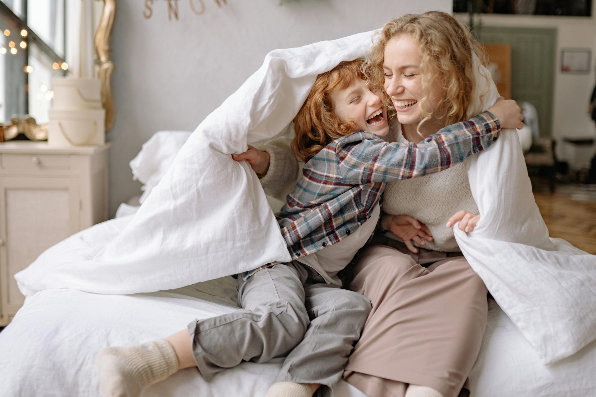 A young fair haired woman and her child celebrating in their home after she was successful for secured loans for bad credit