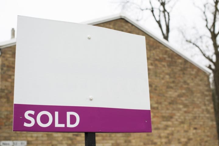 house sold sign with purple background