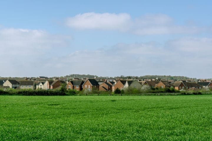 row of houses backing onto green field