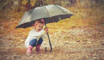 Child under umbrella in the rain