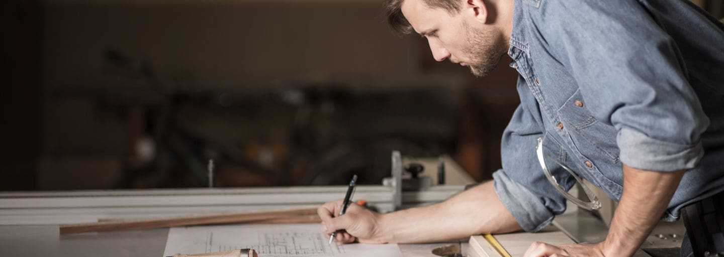 male wood worker writing on paper